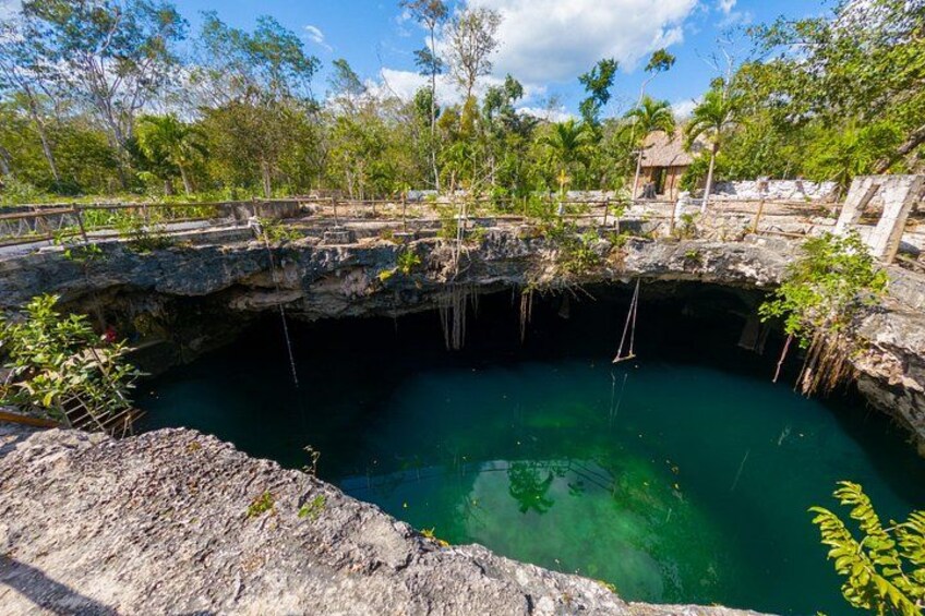 A natural pool with clear water, surrounded by rocky terrain and vegetation. 1