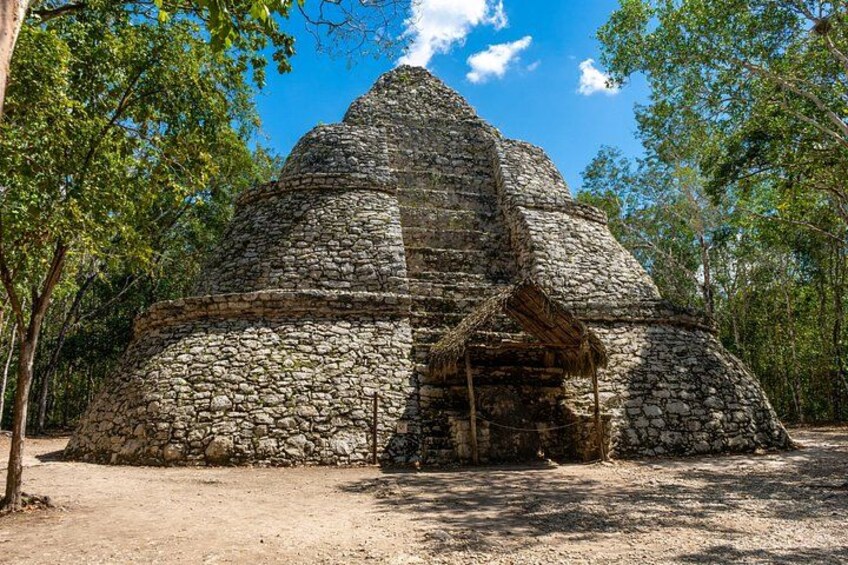 A stone pyramid structure surrounded by trees. 2