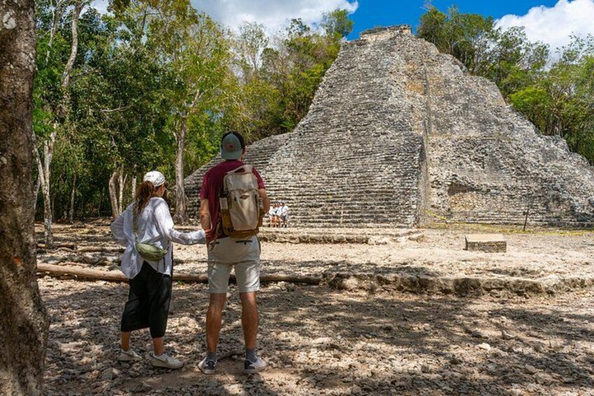 A large ancient pyramid structure surrounded by trees. 4