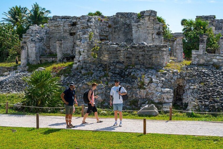 Ancient ruins with tourists walking on a paved path. 3