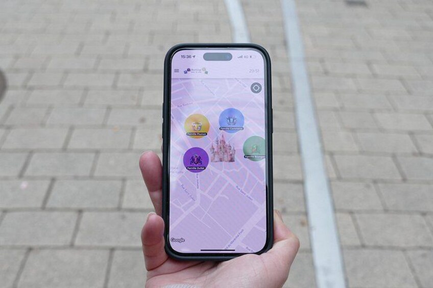 En hand håller en smartphone som visar en karta med markörer för olika platser. 1