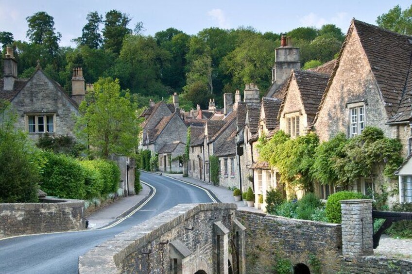 A narrow stone bridge over a road, surrounded by traditional stone houses with pitched roofs. 2