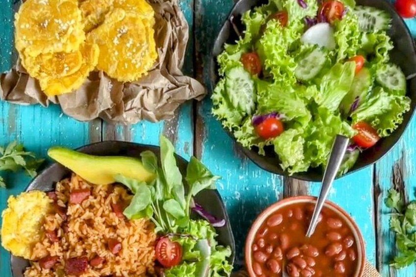 Diverse soorten eten, waaronder een salade, bonen, gebakken plantains en rijst. 2