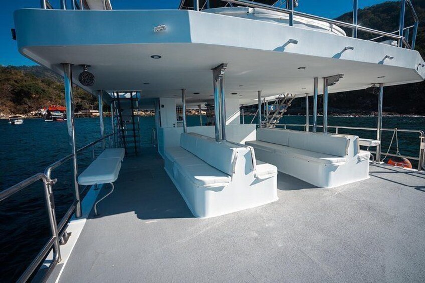 A boat deck with seating, railings, and a clear view of the water. 3
