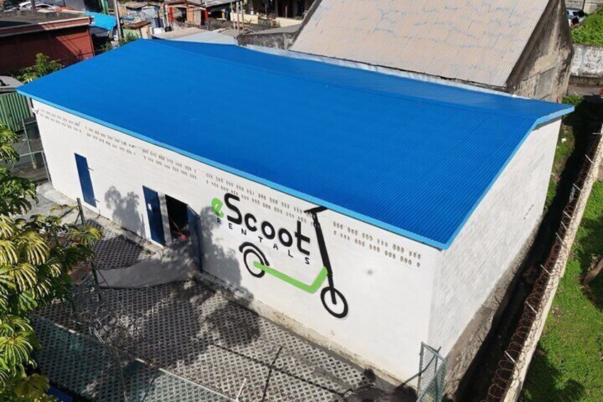 A building with a blue roof and a scooter rental sign. 4