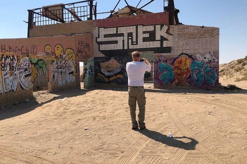 A person taking a photo of graffiti on a wall. 3