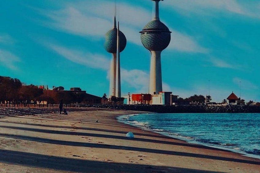 A beach with two spherical towers in the background. 1