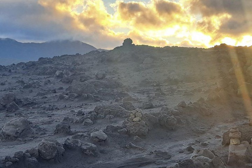 Gerölliges Gelände mit vereinzelten Felsen und einem Berg im Hintergrund. 4
