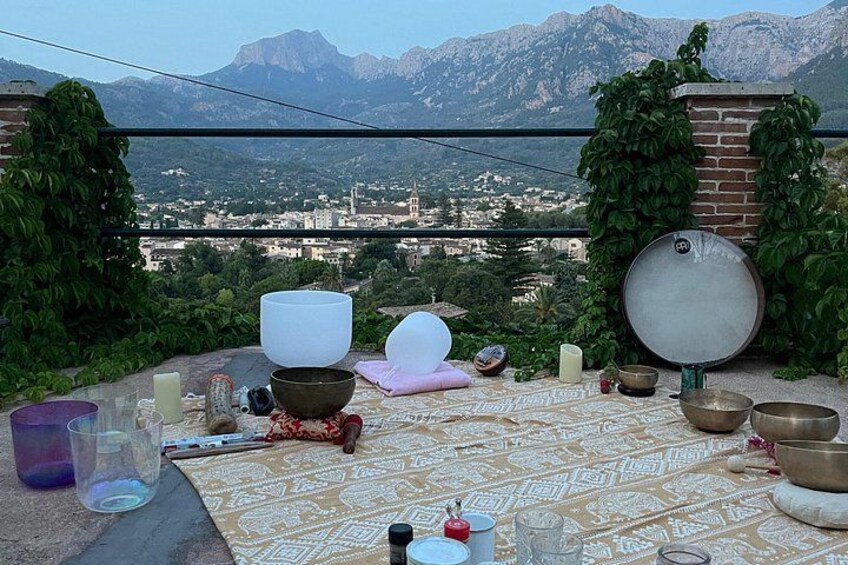A table with bowls and a mirror, set against a mountain backdrop. 1