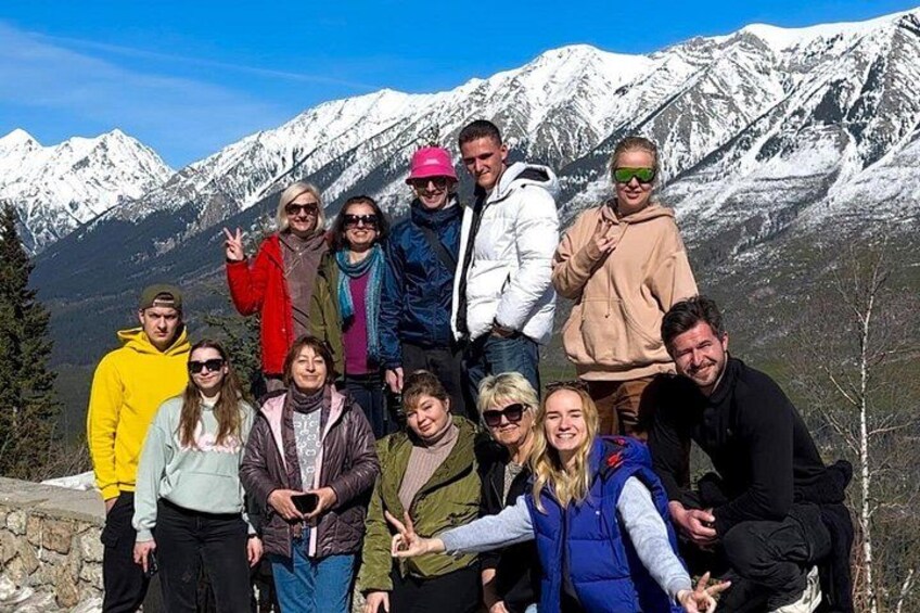 A group of people posing in front of snow-covered mountains. 3