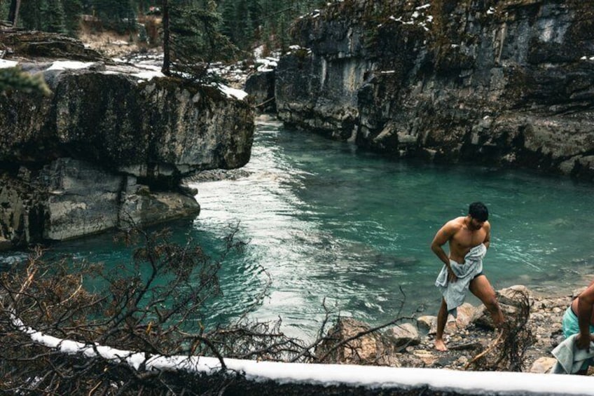 A river flowing through a rocky canyon with a person standing on the edge. 3