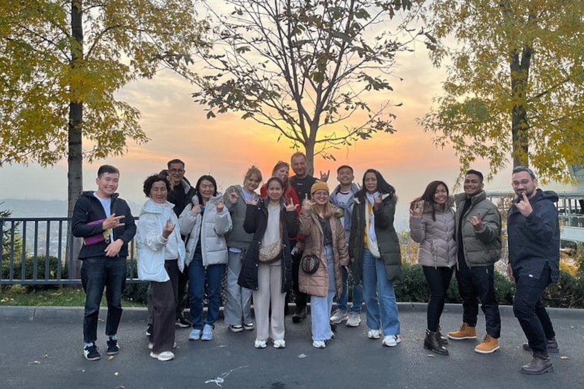 A group of people standing outdoors during sunset. 4