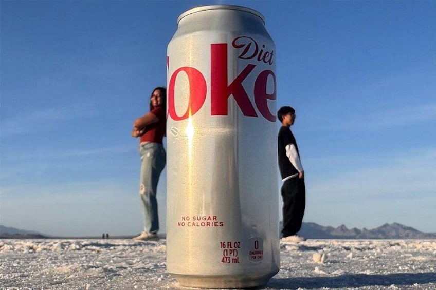 Una lata de Coca-Cola Light con una persona de fondo. 1