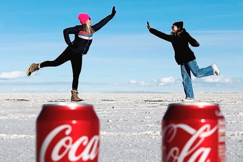 Two people balancing on ice with Coca-Cola cans in the foreground. 2
