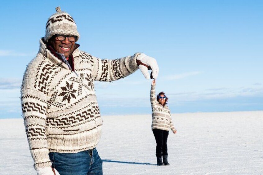 A person in a patterned sweater and hat standing in a snowy landscape. 5