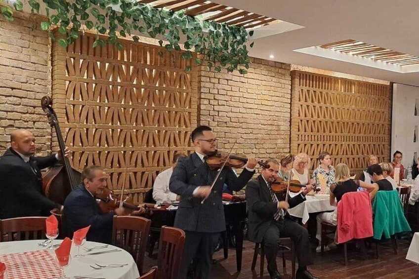 A group of musicians performing in a restaurant with wooden paneling and brick walls. 1