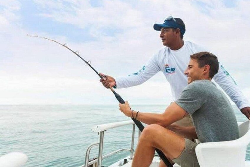 Two people fishing on a boat with calm sea and clear sky. 2