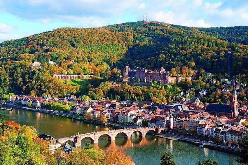 A river with a bridge, a town with historic buildings, and a hill with trees. 4