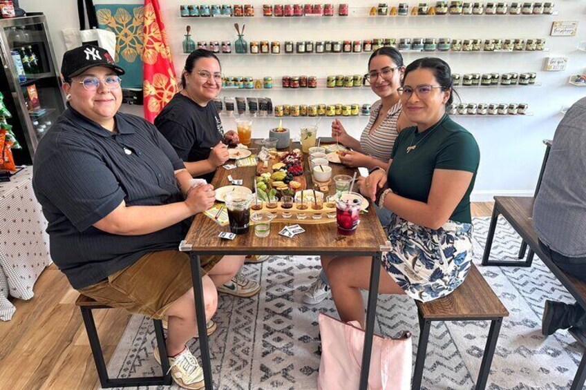 Four people seated at a table with various food items and drinks. 2