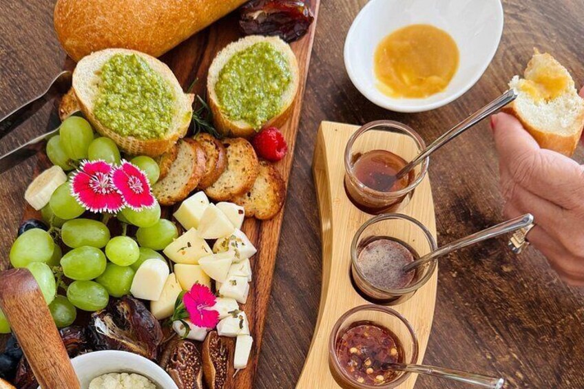A charcuterie board with grapes, cheese, bread, and various spreads. 4