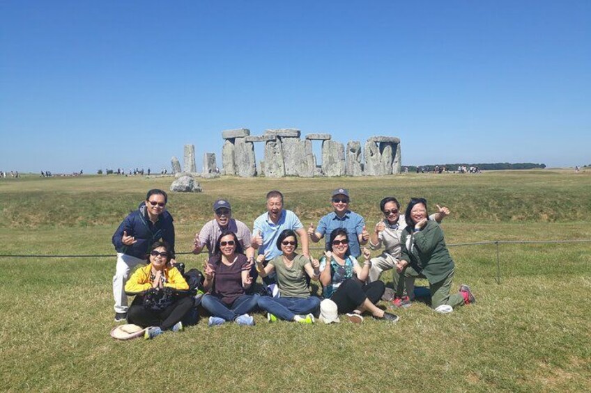 Un grupo de personas posando frente a Stonehenge. 1