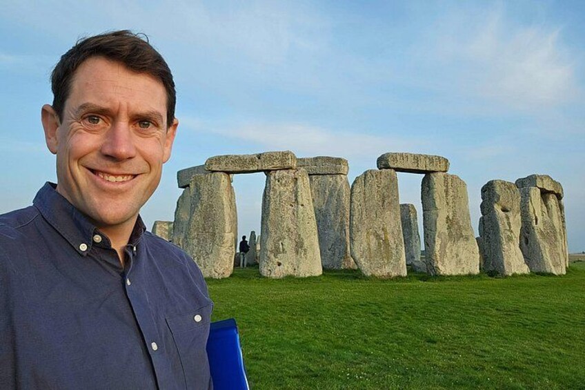 Una persona de pie frente a Stonehenge, con el círculo de piedras emblemático al fondo. 3