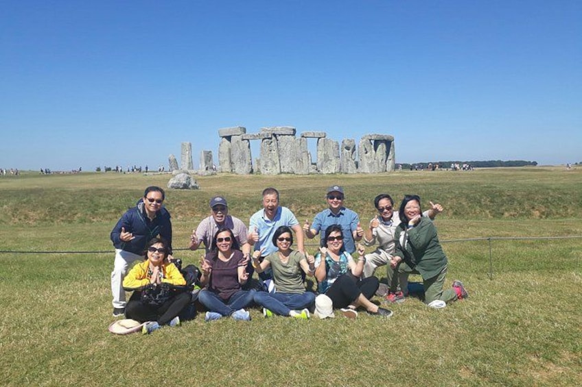 En gruppe mennesker poserer foran Stonehenge. 1