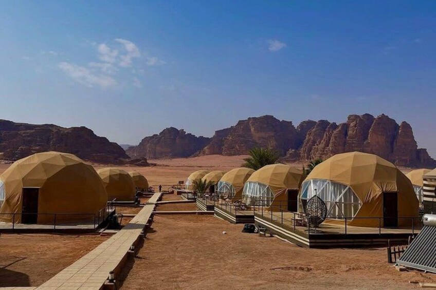 Una fila de tiendas en forma de cúpula en un paisaje desértico con montañas rocosas al fondo. 4