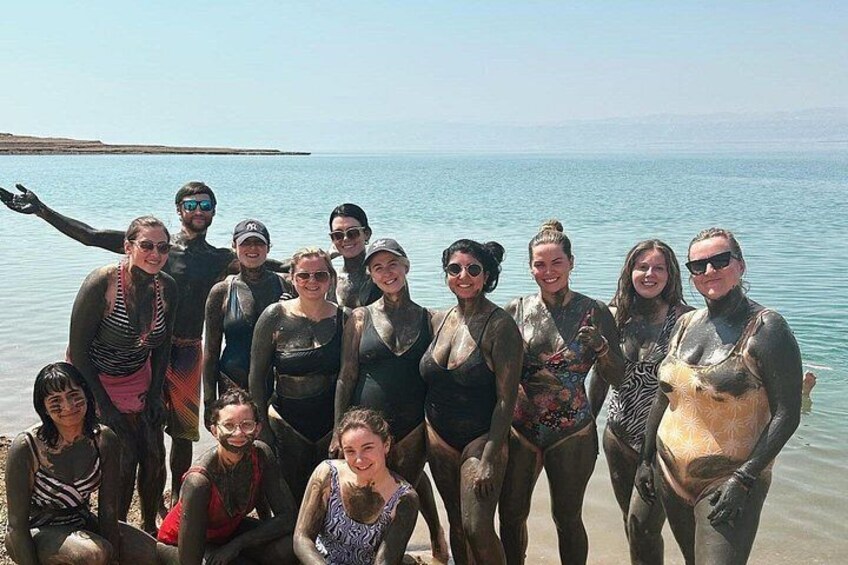 Un groupe de personnes se trouve sur une plage où l’eau est calme et le ciel est dégagé. 4