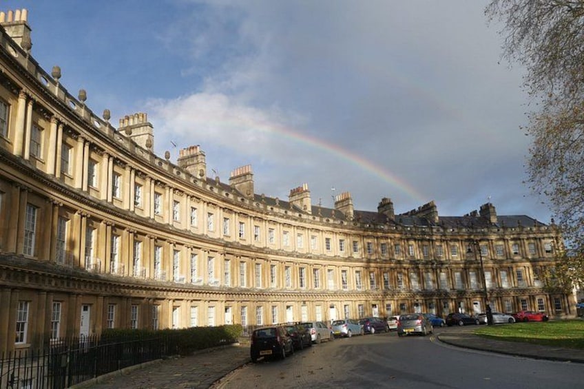 A row of classical buildings with a rainbow in the sky. 4