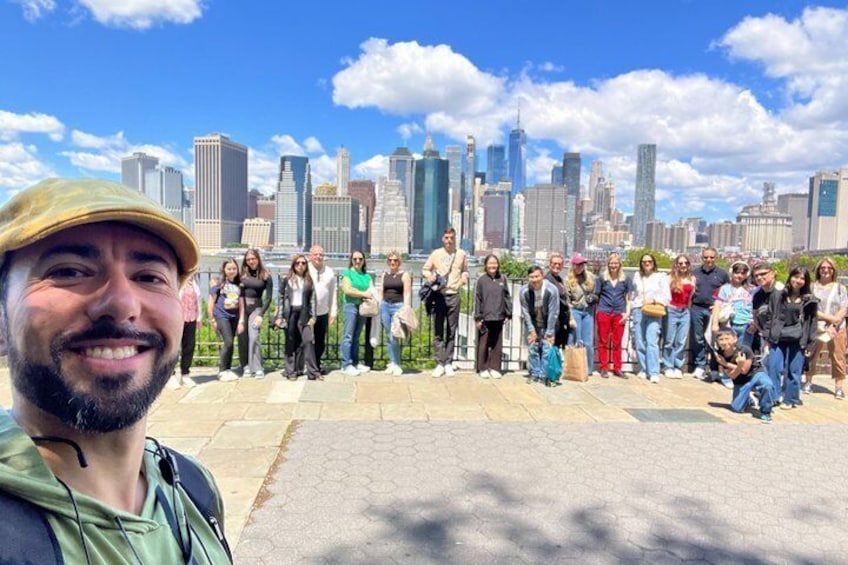 A group of people standing in a city park with a skyline in the background. 3