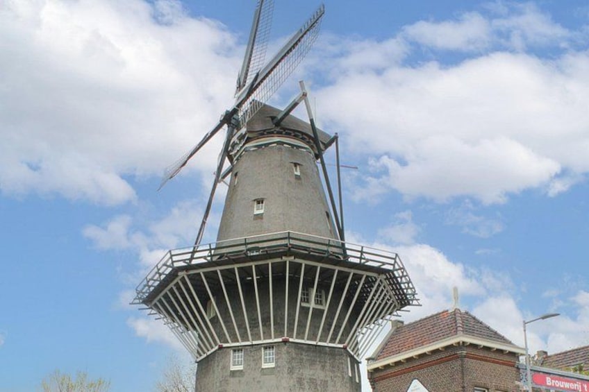A traditional windmill with a large sail and a protective fence. 3