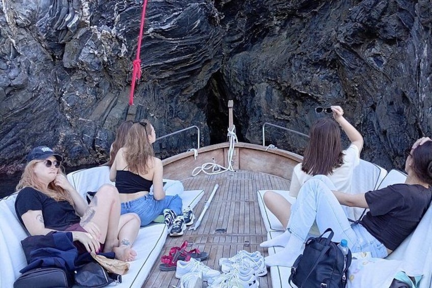 Un grupo de personas en un bote, con acantilados rocosos al fondo. 2