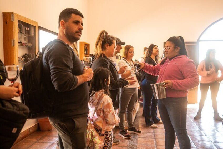 A group of people standing in a room, some holding wine glasses. 2