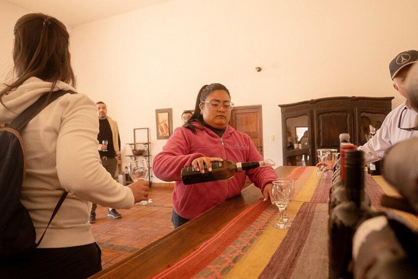 Una persona sirve vino en un vaso en un bar. 4