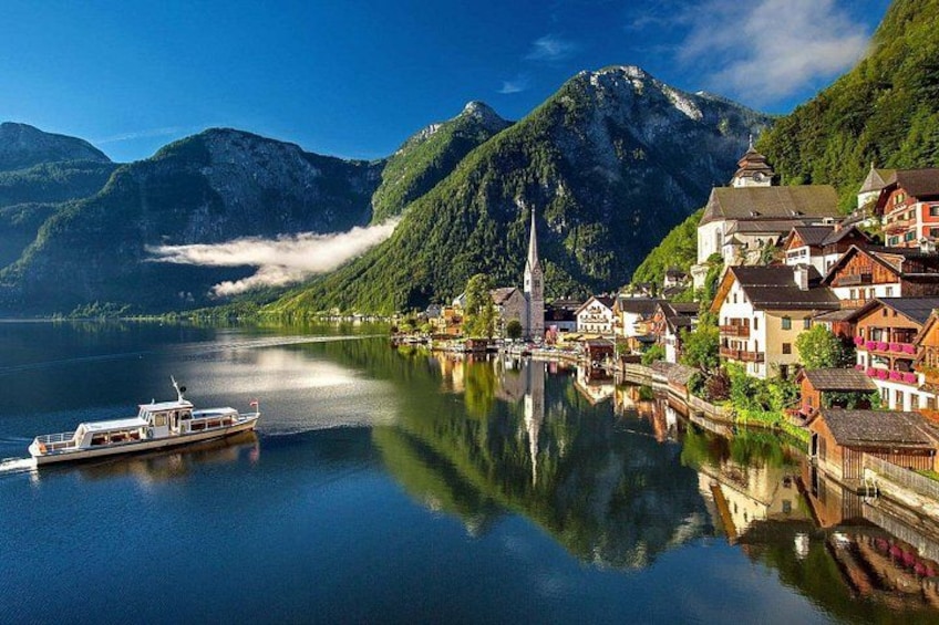 Un lago con una barca, una chiesa e case lungo la riva. 3