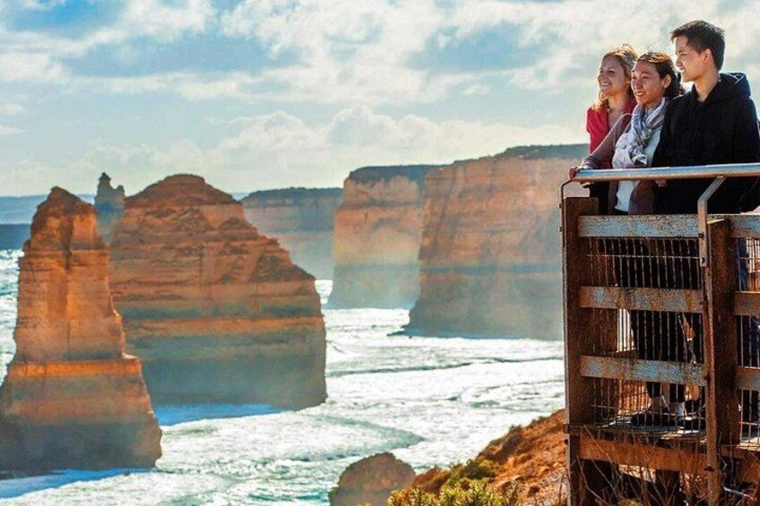 A coastal landscape with prominent rock formations and a metal railing overlooking the ocean. 3
