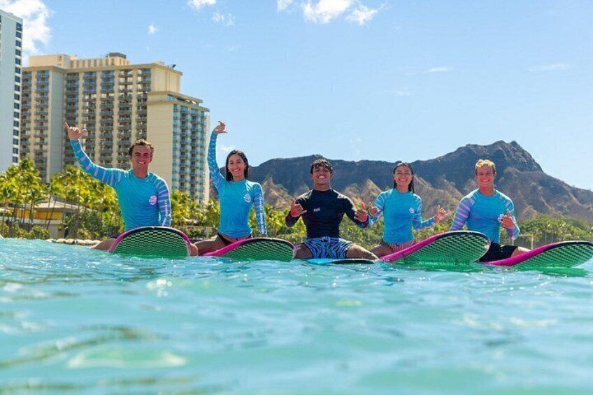 Un grupo de personas sobre tablas de surf en un cuerpo de agua, con un paisaje montañoso al fondo. 2