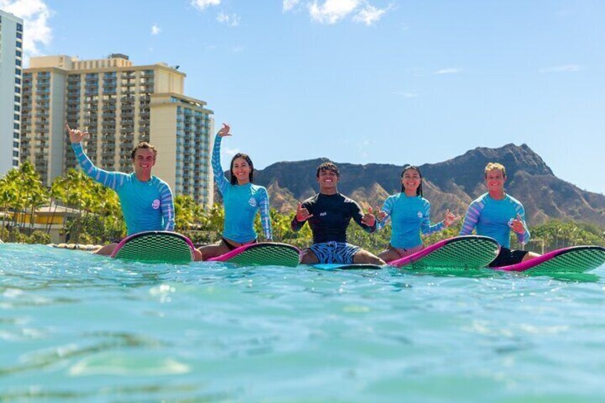 A group of people on surfboards in a body of water with a mountainous landscape in the background. 2