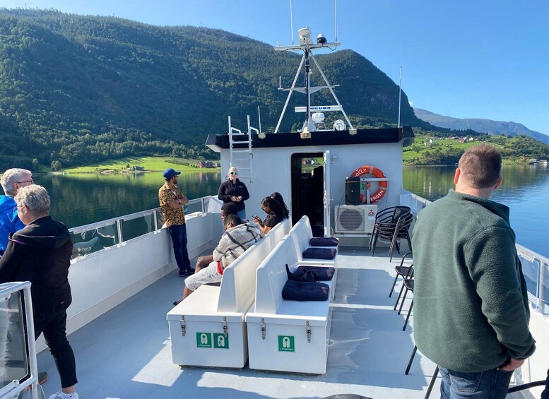 A boat with passengers enjoying the view of a lake and mountains. 5