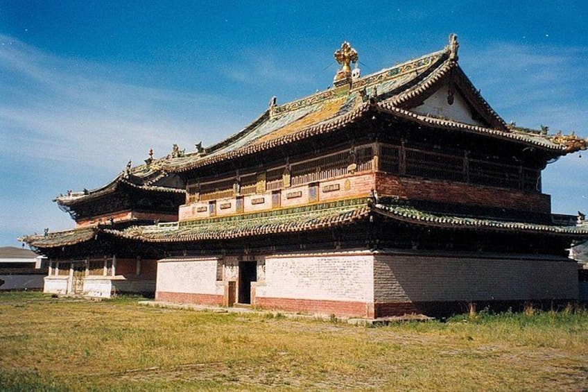 A traditional multi-tiered building with ornate roof details and a brick base. 3