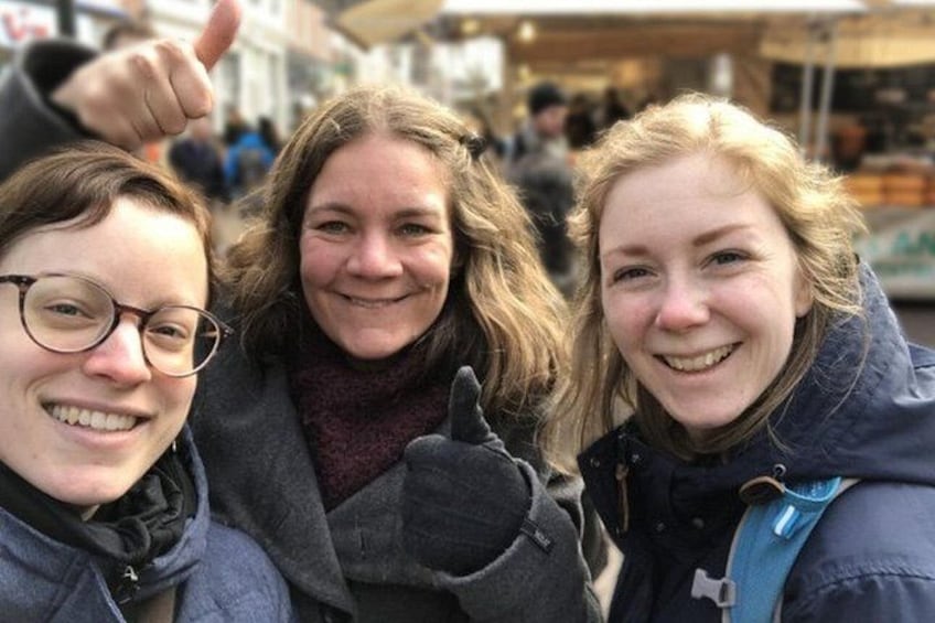 Three people outdoors, one giving a thumbs-up. 4