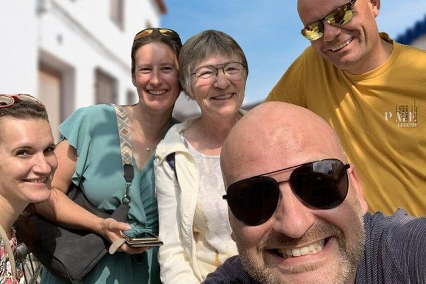 A group of people standing outdoors with a building in the background. 5