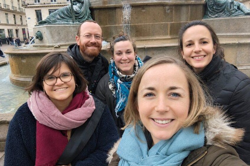 Eine Gruppe von Menschen steht vor einem Brunnen mit Statuen. 2