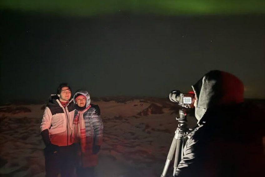 Dos personas de pie sobre nieve, mientras una cámara sobre trípode las fotografía. 5