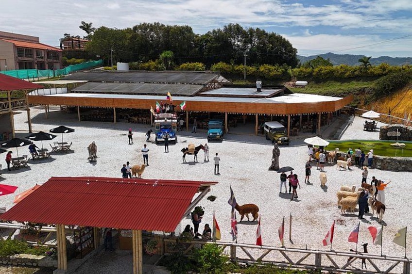 An outdoor market with people, animals, and vehicles. 1