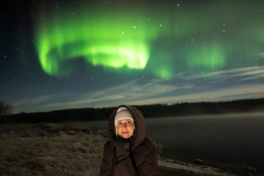 Una persona de pie al aire libre de noche, con la aurora boreal en el fondo. 3