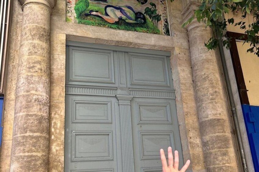 Una puerta grande y ornamentada con intrincados grabados, flanqueada por dos columnas y un mural decorativo encima. 2