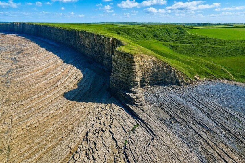 A large cliff formation with layered sedimentary rock. 1