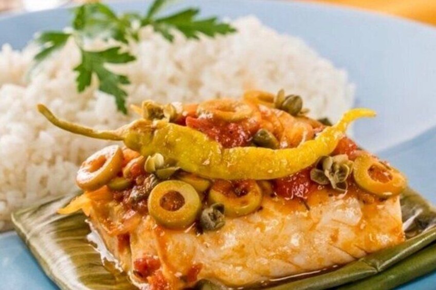 A plate of fish with olives, capers, and a yellow pepper, served with rice. 5